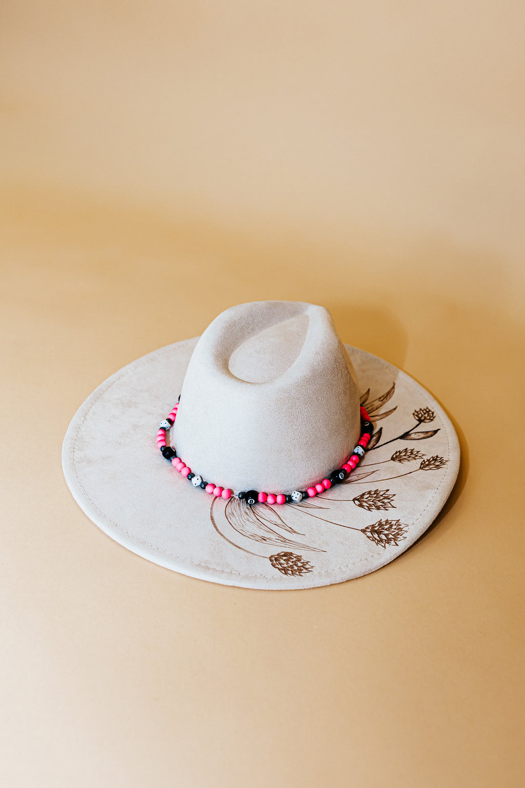 White hat with a decorative band on a beige surface